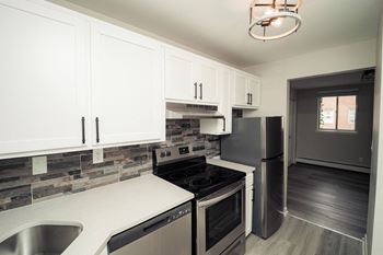 A kitchen with stainless steel appliances and white cabinets